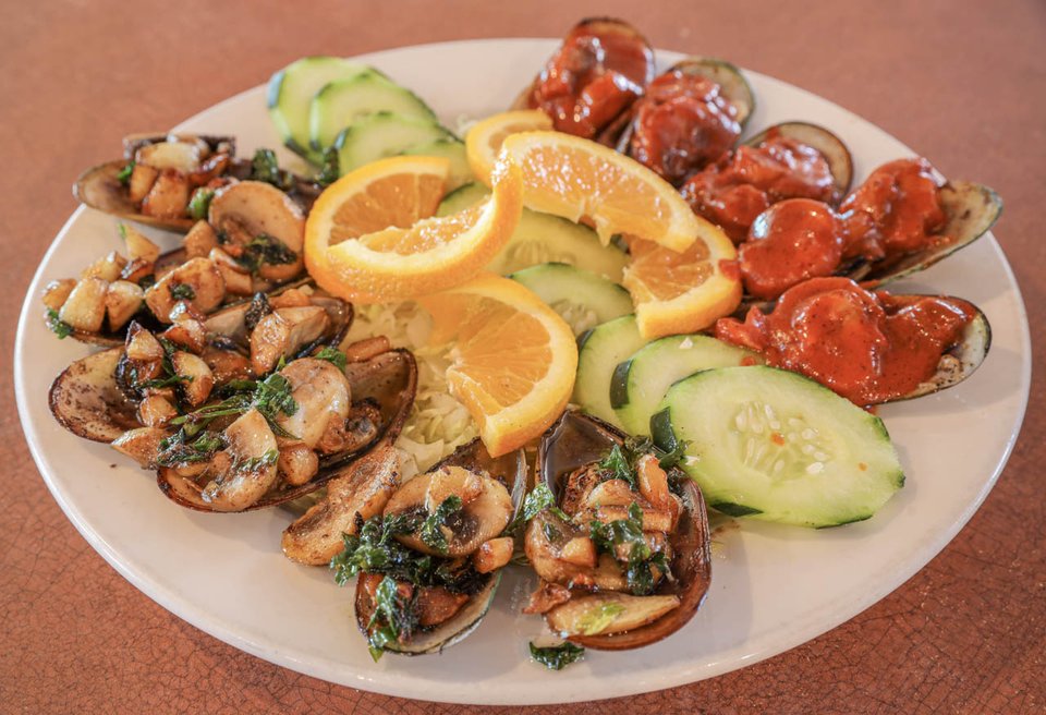 Seafood dishes served with fresh garnishes.